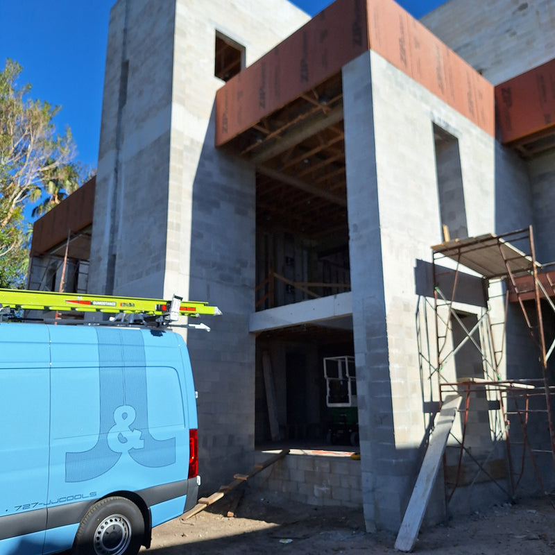 J&J Refrigeration Inc. truck in front of a residential construction site