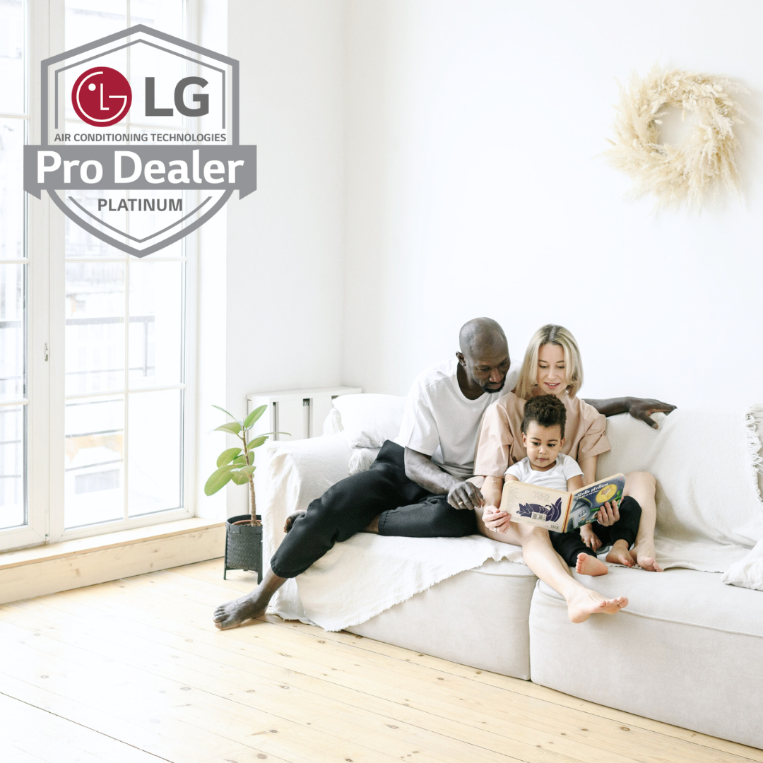 A family sitting on a couch together reading a book. (LG Pro Dealer Logo on the image)