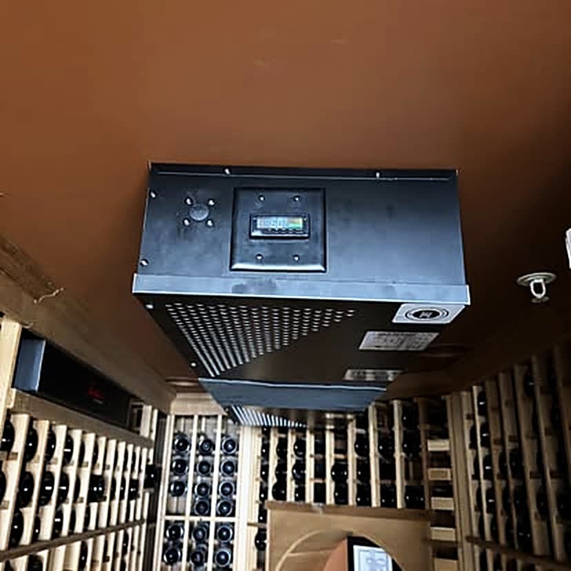A ceiling-mounted wine cellar cooling unit with a digital controller, above timber racking