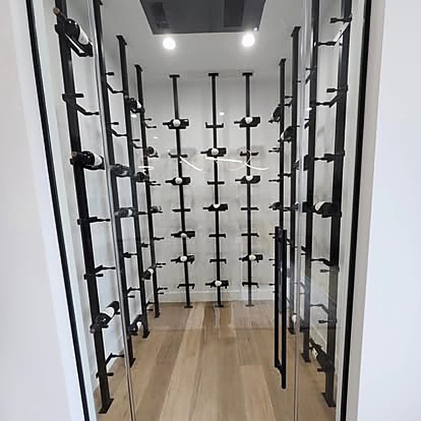 The entrance to a walk-in wine cellar with black peg racking and a timber floor