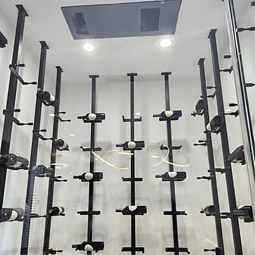 A white wine cellar with black metal peg racking and a ceiling supply grille