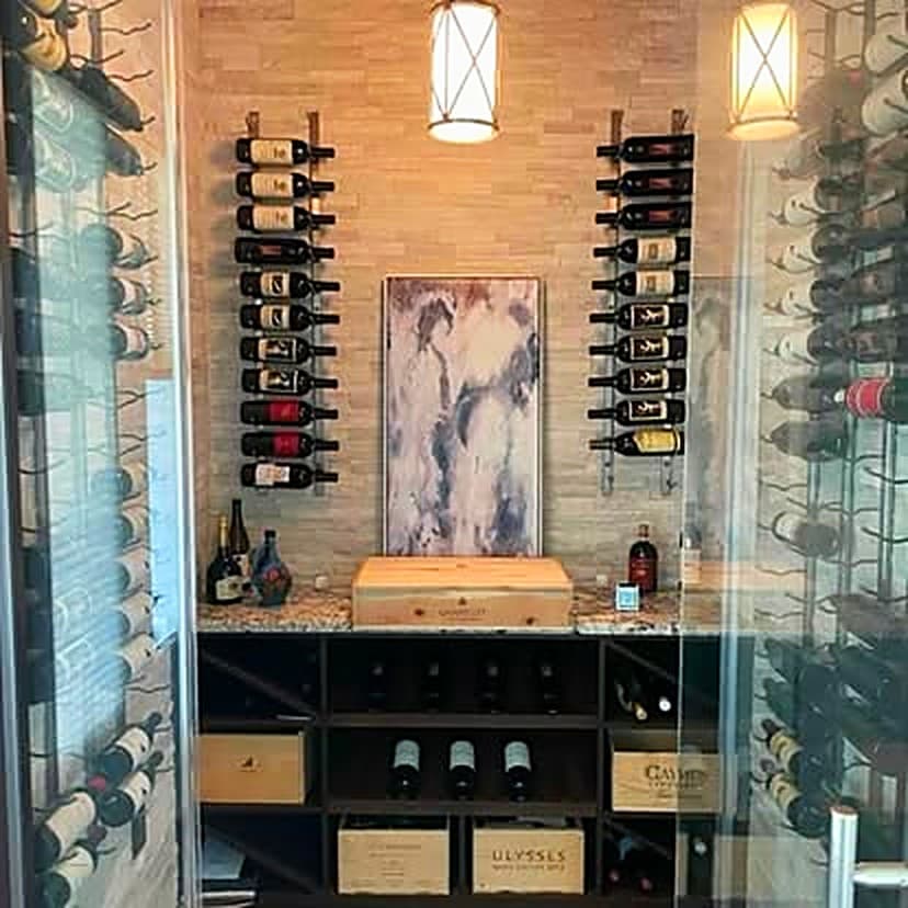 A wine room with a stone tasting counter, wall-mounted racking and pendant lights