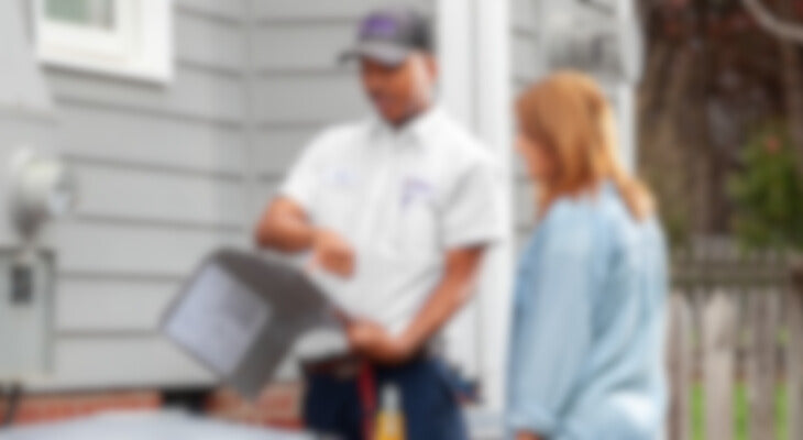 A HVAC Tech helping a woman blurred.