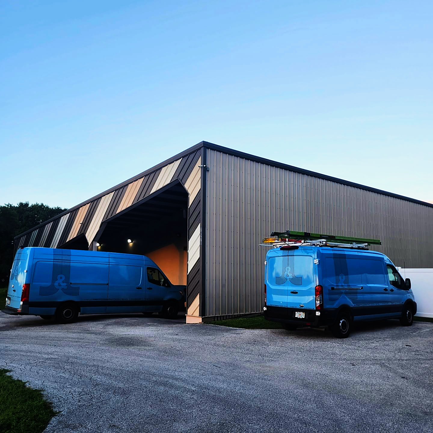 The J&J Refrigeration shop in Clearwater, with two branded service vans parked outside